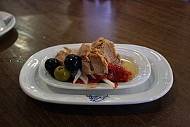 Tapa de bonito en escabeche aderezado en cebolla y olivas.