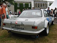 Photo d'une voiture de course de couler grise vue de l'arrière.