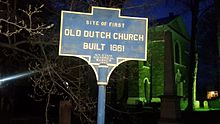 a picture of the marker with the church, bathed in green light, in the background