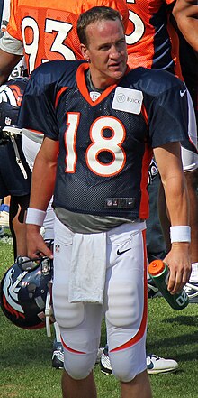 Peyton Manning holding his helmet