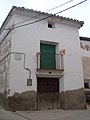 Casa del pueblo con puerta de madera labrada.