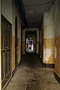 An old basement corridor with flagstones. The corridor is long and extends into the distance.