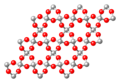 Silice cristallisée (SiO2)n (atomes Si en gris et O en rouge)
