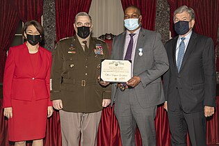 Goodman receives the Joint Meritorious Civilian Service Award (from left: Senator Amy Klobuchar, Chairman of the Joint Chiefs of Staff Mark Milley, Goodman, and Senator Roy Blunt).