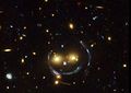 Image fournie par la NASA, via Hubble : une lentille gravitationnelle située à 4,5 milliards d’années-lumière de la Terre donne l’impression d’un gigantesque smiley.