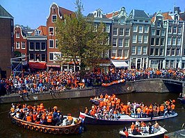 Amsterdamse grachten kleuren oranje met feestvierders en bootjes, hier op de Prinsengracht tijdens Koninginnedag 2010.