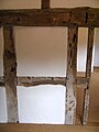 Internal oak timbers, much perforated by woodworm, on the first floor of the 16th-century farm building.