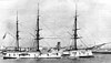 A white-painted, three-masted ship with a black funnel