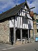 A medieval, timber framed merchant's house, with a barrel hanging over the street