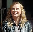 Melissa Etheridge, a White woman with long blonde hair, wearing a black, leather jacket