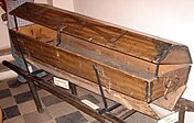 Reusable coffin with an open trapdoor