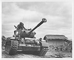 Un M46 Patton pasando por la aldea de Kumko, Corea, en setiembre de 1950.