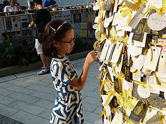 Girl inspects messages on a pillar