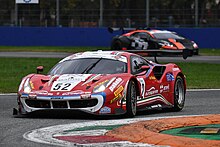 Eurospares sponsored Ferrari racing around a corner on the track during the GTC racing event.