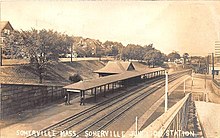 A postcard of a small railway station with a lengthy canopy