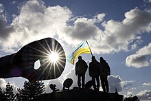 Ukrainian military personnel standing on top of a Challenger 2 main battle tank in the UK