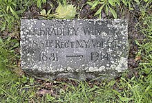 A small, stone rectangular gravestone in the ground reading "Bradley Winslow, 186th Regt N.Y. Vol. Inf., 1831-1914"