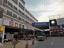 A white building consisting of ground floor shops with apartments/hotel rooms above