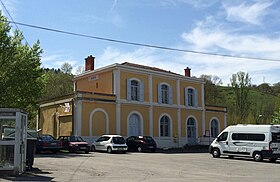 Photo de la place de la gare avec le bâtiment voyageurs d'origine.