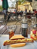 German Hot Dog version served here in Berlin, Germany. In Germany, such sausages are heated in a kettle of hot broth, but are also often grilled, then served in a crunchy bun. The German term for this grilled street food is “Bockwurst” or ”Bratwurst im Brötchen.”