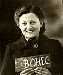 Photo en noir et blanc d'une jeune femme souriante, portant une petite ardoise avec le nom "Bohec"