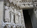 Les quatre grandes statues du piédroit de gauche du portail de la Vierge refaites au XIXe siècle représentent un roi non identifié et saint Denis décapité, portant sa tête et entouré de deux anges.