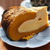 Slice of yellowish pumpkin custard with brown shell