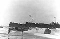 LST-344, (left) and LST-338 (right) unloading troops and supplies on the Gela invasion beaches in Sicily on "D-Day" 10 July 1943. Broached LCVP at right is from the Barnett (APA-5); the next LCVP to the left is from the Monrovia (APA-31).