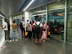 Line of people entering bus at Sweileh terminal