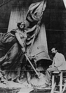 Photograph of Fernand Hamar working on the statue