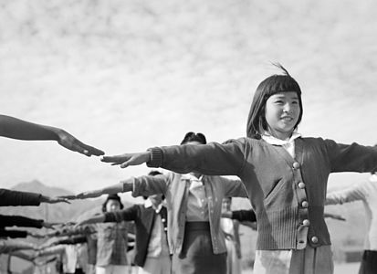 Female internees practicing calisthenics at Manzanar, by Ansel Adams (edited by trialsanderrors)