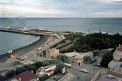 Vista del área de la parada céntrica al costado de un edificio de un piso antes de que las vías, junto al parque Soberanía, tomaban curva rombo estación Comodoro Rivadavia. El área fue reformada y la gran curva y el empalme fueron anulados desde 1971 cuando en el espacio vacío del parque se colocaron las vías al puerto y más al norte se traslado el empalme al puerto.