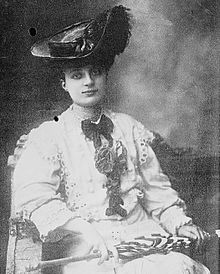Photograph of Anna de Noailles seated with a hat on her head.