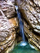 Cascade traversant des couches de dolomie, de calcaire cristallin et de prasinite.