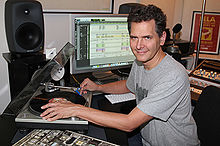 Craig Kallman holding a vinyl record at a recording workstation