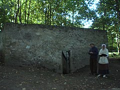 Vue extérieure de l'enclos entourant la fontaine aux Moines, avec la porte d'entrée.