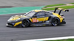 A gold and black Porsche 911 RSR being driven at Silverstone Circuit in 2018