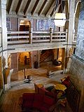 Interior photograph from the second level of the lobby showing massive wooden beams and numerous works of art.