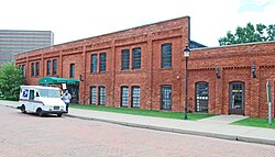Two-story brick building with United States Postal Service vehicle in front of it