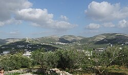 Ijnisinya in the center. On the left are the houses of Sebastia. Hidden behind the antenna is Nisf Jubeil and Zawata behind the mountain on the right side followed by the city of Nablus.