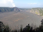 Vue générale du Kīlauea Iki avec le Puʻu Puaʻi au centre et la fumée s'échappant du Halemaʻumaʻu au dernier plan.