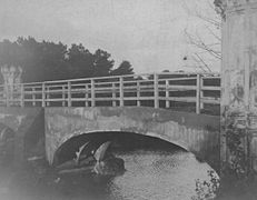 The repaired bridge. Note the simple wooden handrail and the remaining exposed iron arch.
