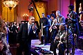 Color photo of Barack Obama singing into a microphone with B.B. King and other musicians and guests.