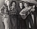 Four students with guitar, Four male students dressed as cowboys. The one on the right holds a guitar.