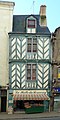 Photographie d'une façade de maison à colombages à motifs en chevrons.