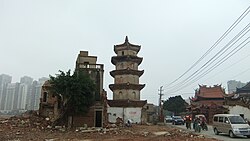 Surviving White Pagoda (center) of Shuixin Chan Temple (right), with the adjacent old residential neighborhood (left) demolished, to make way for new development (such as seen in the background)
