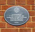 Plaque to Adrian Fortescue on the side of Fortescue Hall, the former church building