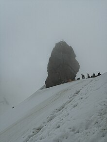 Picture of a shivalingam sitting atop a mountain.