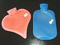 Two modern hot water bottles shown with their stoppers