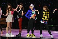 Four women wearing colourful, mismatched casual clothing and trendy sneakers